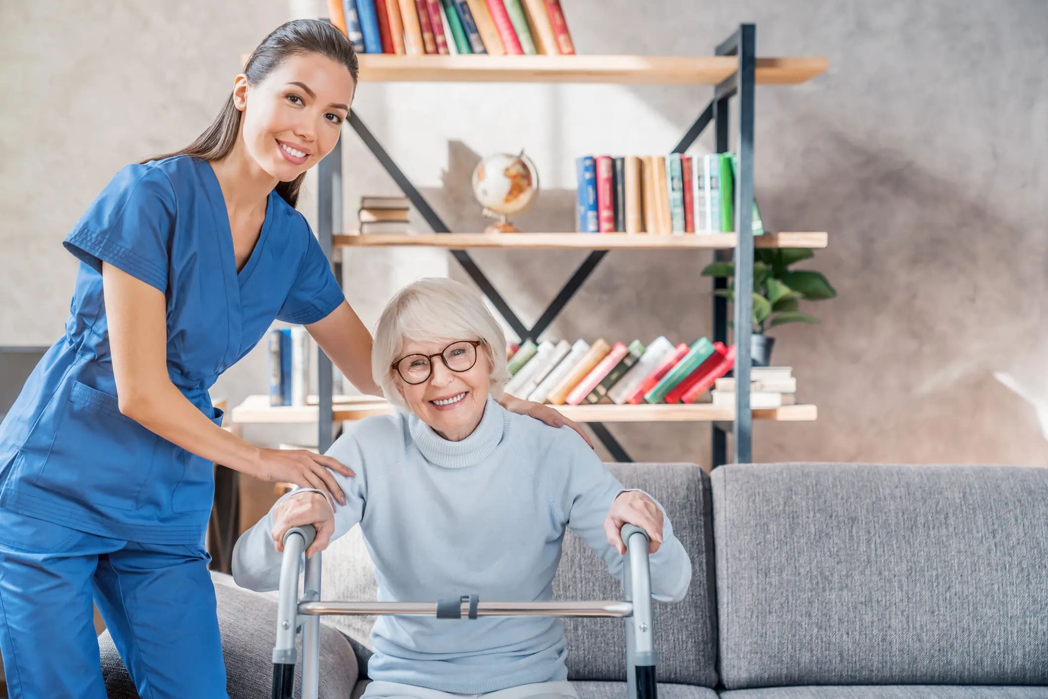 a caregiver helps a woman using a walker. smiling indoors. caucasian