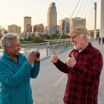 An elderly couple in Omaha taking photos at the Bob Kearny pedestrian bridge